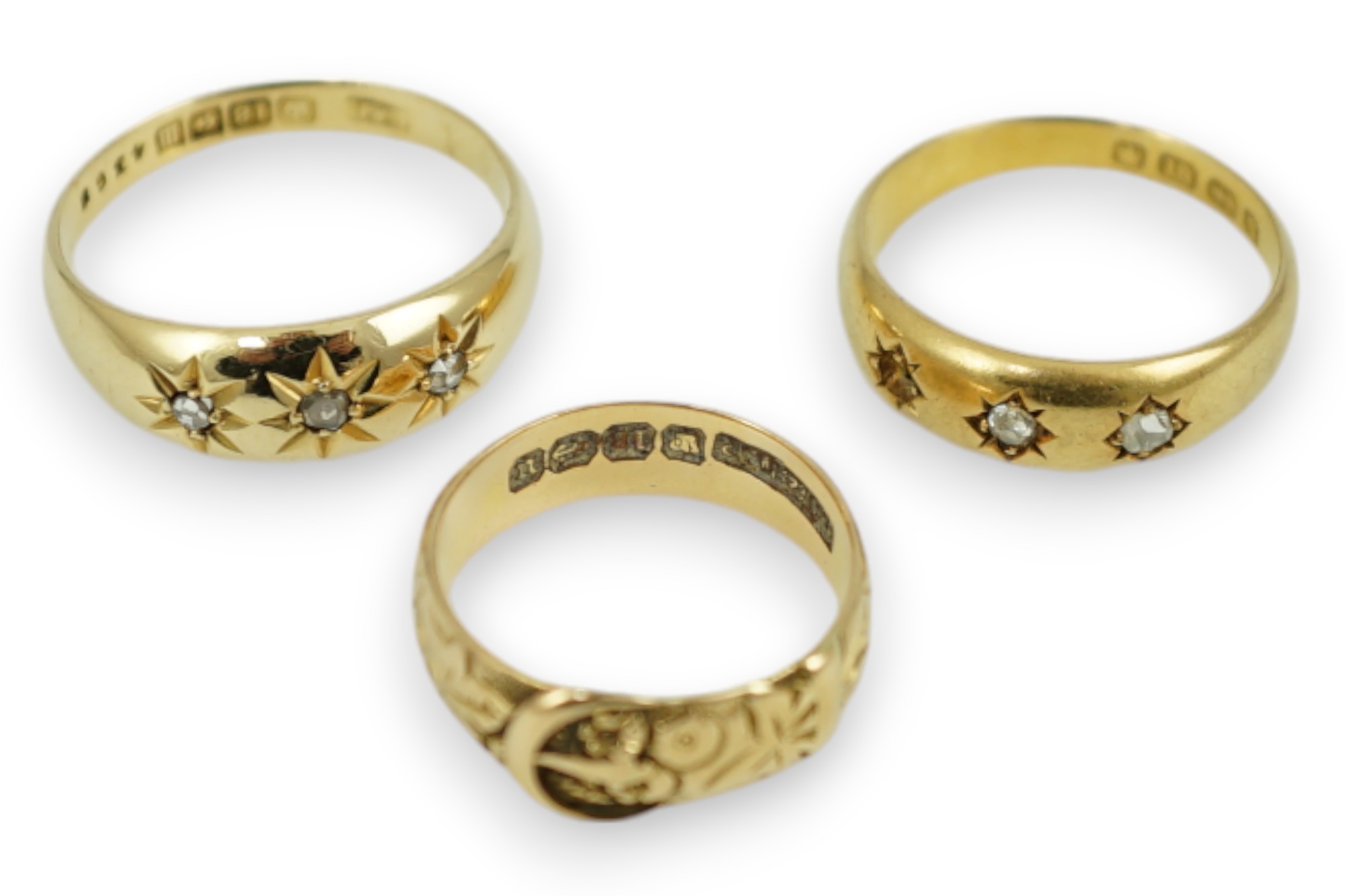 A Victorian 18ct gold buckle ring, size K/L, a Victorian 18ct gold and gypsy set three stone diamond ring (stone missing) and a later 18ct gold and gypsy set three stone diamond ring